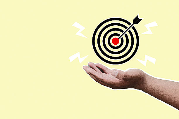 istock Halftone hand holding target board icon with arrow hitting the red center on yellow background. Business goal achievement, marketing strategy, and success concept. 2257202827