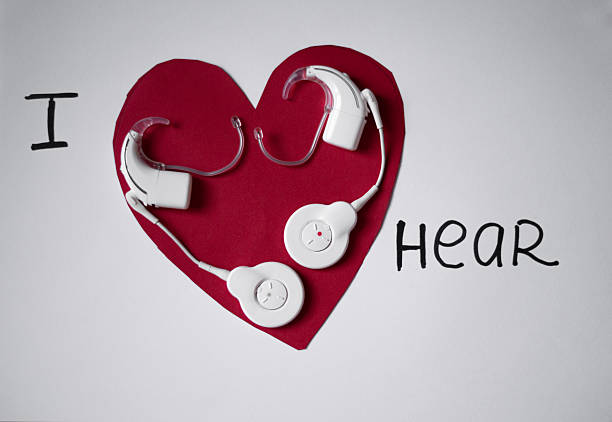 Cochlear hearing implants placed on a heart-shaped background. Concept of hearing care, medical technology, love, inclusion and support for people with hearing loss.