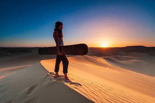A sporty woman in the Ica desert Peru runs on golden sand dunes near the iconic Huacachina Oasis