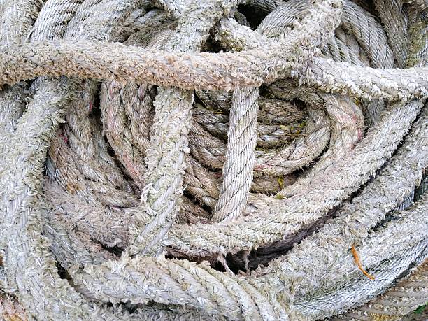 Old, worn maritime rope traditionally used on sailing ships for securing sails, rigging, and various nautical purposes. The visible wear and texture reflect long-term use in harsh sea conditions. This rope symbolizes maritime history, seafaring craftsmanship, and traditional nautical equipment, making it ideal for themes related to sailing, navigation, vintage maritime tools, and coastal heritage.