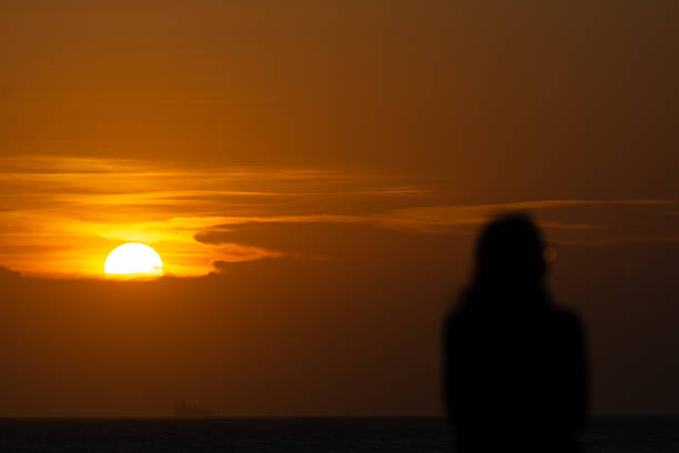 Salvador, Bahia, Brazil - January 2, 2026: Person, in silhouette, during the sunset on the horizon of the sea in the city of Salvador, Bahia.
