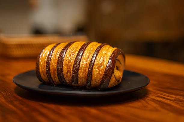 Chocolate croissant served on coffee shop table.