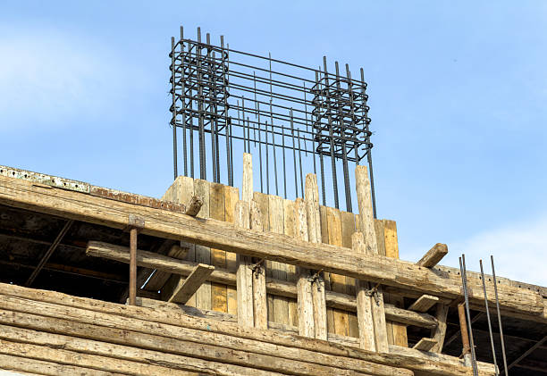 Reinforced concrete column featuring exposed rebar and wooden formwork on a building construction site in Athens, Greece