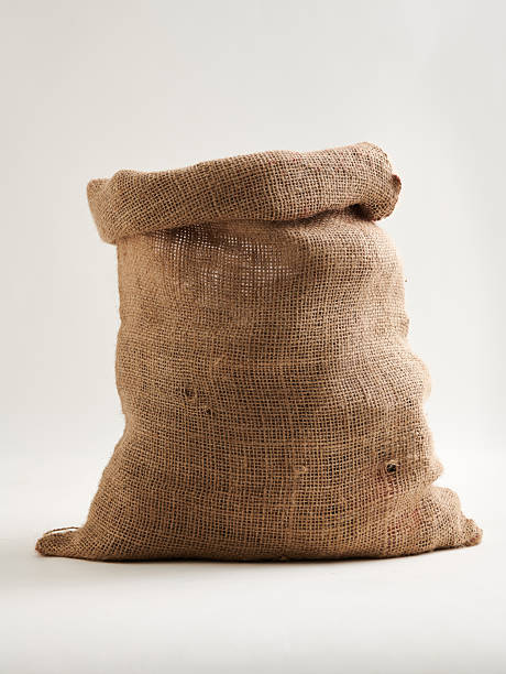 Empty burlap sack (jute / hessian bag) isolated on white background. Rustic textile packaging for agriculture, storage, shipping, coffee beans, grains, and eco-friendly sustainable concept.