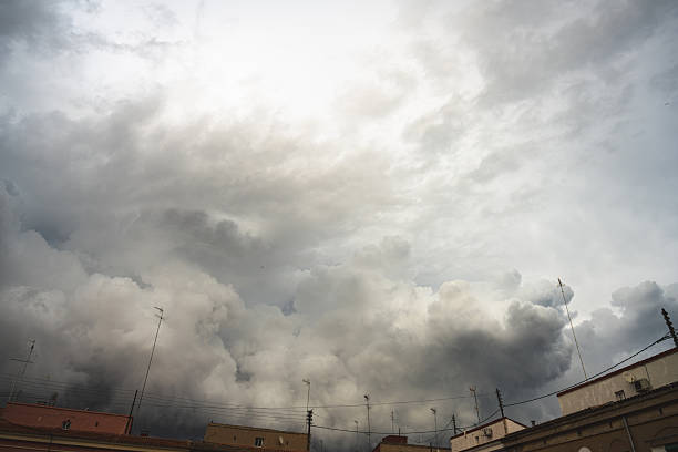 Dark storm clouds hang over the buildings. The sky is overcast, and the sun shines through the clouds. Low, dark clouds create a terrifying atmosphere.