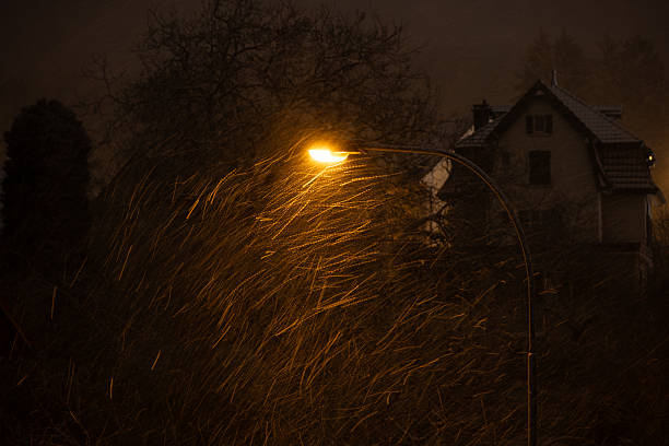 Street light illuminating falling snow at night. Long exposure, blurred motion, above view, no people