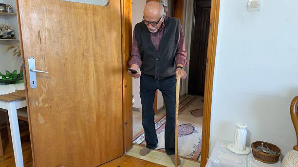 Elderly man with a walking cane using smart phone