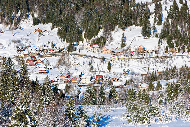 Top view of a small village at the foot of the mountains in Romania. Snowy village.