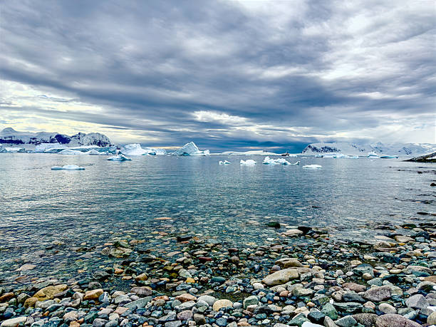 Epic Antarctica Frozen Landscape Sun on Ocean. Fine Art Photography. Sunlight Shines Through Clouds to Illuminate Seas and Islands.