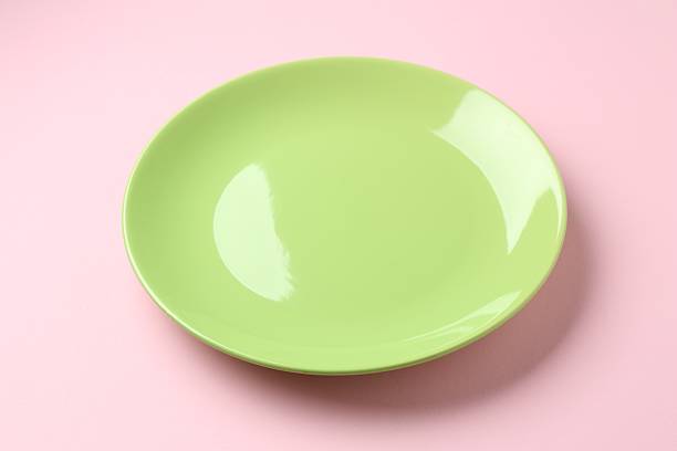 One stylish plate on pink background, closeup