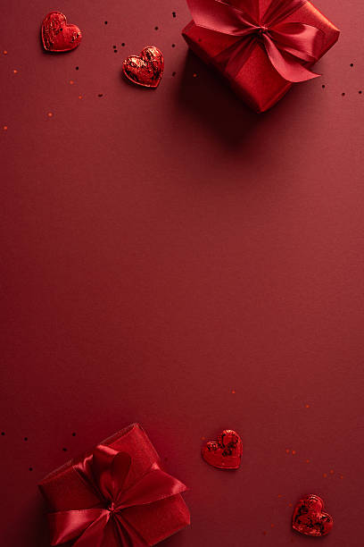 istock Red vertical background decor with gift boxes, ribbons and heart chocolates creates a romantic Valentine mood, ideal for greeting cards, gift campaigns, and festive promotions 2257273609