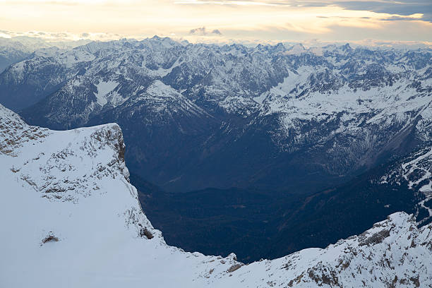 Landscape panorama of the European Alps mountain ranges with snow-covered peaks under blue sky.