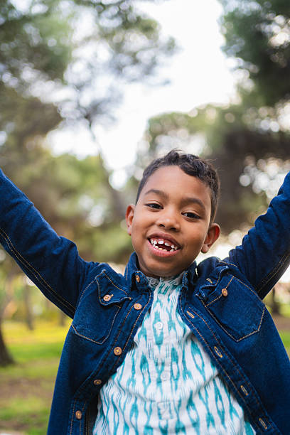 istock Happy child outdoors raising arms playing in nature 2257285364