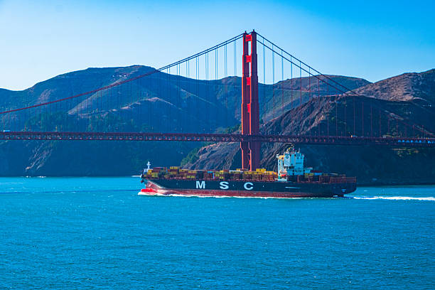 San Francisco, California, USA - October 3, 2025:  Container ship traffic streams through the channel under the Golden Gate Bridge.