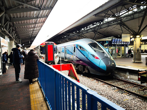Manchester, UK - January 12, 2026: Busy Manchester station scene with passengers waiting while a modern high speed train arrives.