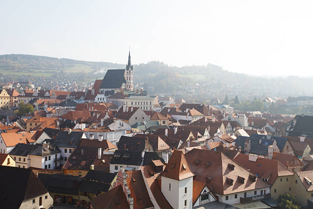Cesky Krumlov old town with river curves, red roofs and historic architecture viewed through an arch. g.
