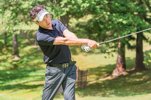 Male golfer hitting a tee shot on a golf course
