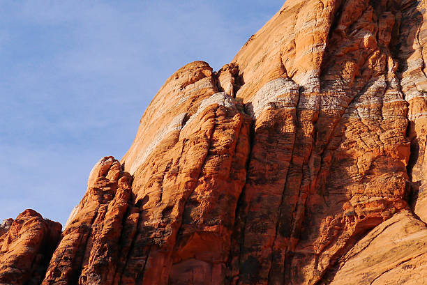 The rock formations of Snow Canyon State Park in St. George, Utah are composed of Navajo Sandstone. The red is due to the high iron content. The white stripe indicates where the iron has been leached out by warm groundwater.  Spectacular views, and completely different in the morning than it is when the sun is setting. 2014.