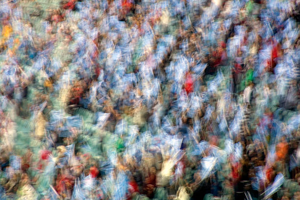 Abstract motion blur of colorful crowd waving flags in stadium, energetic festival or sports fan background.