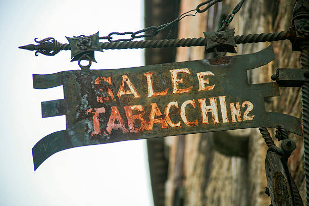 Closeup of weathered Italian “SALE E TABACCHI” shop sign made from rustic metal, evoking old-world charm, patina and traditional European streetscape.