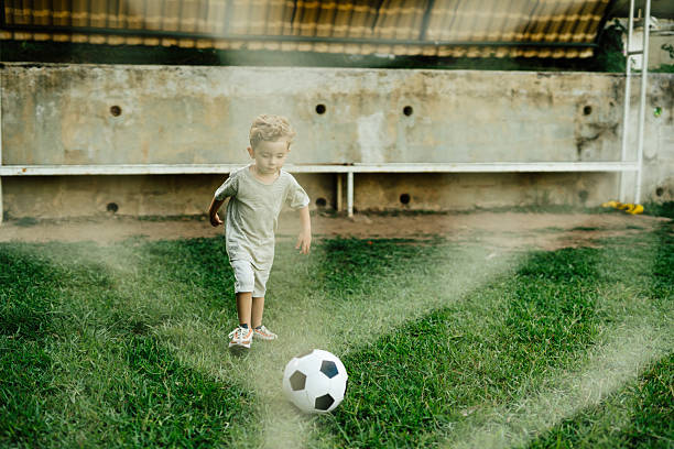 Toddler playing soccer outdoors
