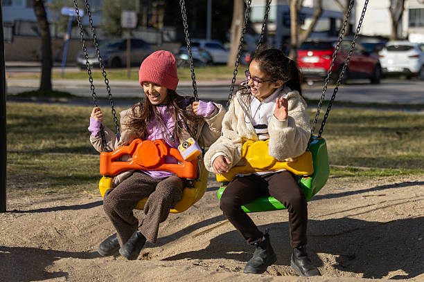 girls playing together on swings