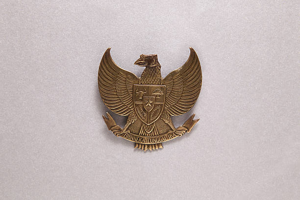 The golden Garuda Pancasila bird emblem with detailed wings and shield is the national symbol of the Republic of Indonesia, representing independence, the five basic principles, and national unity. The Sanskrit text on its ribbon means 
