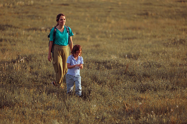 Asian mother and son standing together in a field holding flowers