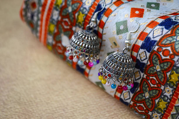 Traditional indian earrings on colorful ethnic fabric background