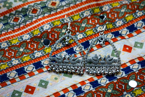 Traditional indian earrings on colorful ethnic fabric background