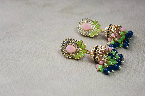 Colorful beaded traditional earrings on textured background