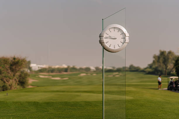 A female golfer focuses on making a fairway shot on a lush golf course, showcasing precision and concentration in her competitive golf attire.