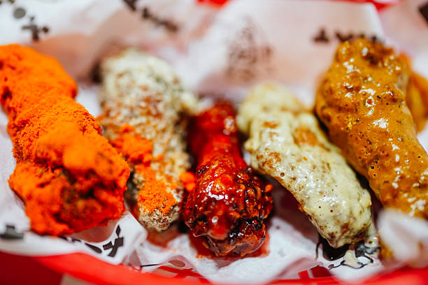 Assortment of fried chicken wings coated in various sauces and seasonings, serving as a popular appetizer