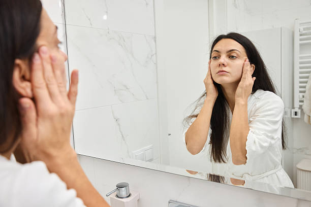 istock Woman applying cream to face during skincare routine 2257346227