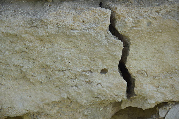 Big winding crack in wild shell stone masonry. Consequences of earthquake. Copy space. Close-up. Selective focus.