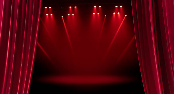Open the red curtain for a stage performance. velvet red stage curtain backdrop with a bright spotlight for a theater cinema show or luxury entertainment event performance