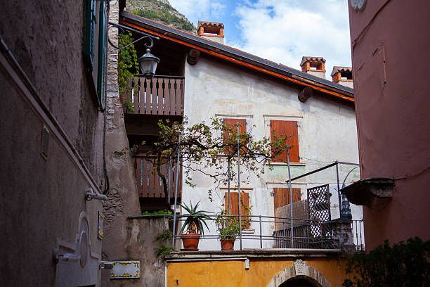 Riva del Garda, Italy – April 08, 2025: Colorful buildings and outdoor cafes with mountains in the background in Riva del Garda, Italy