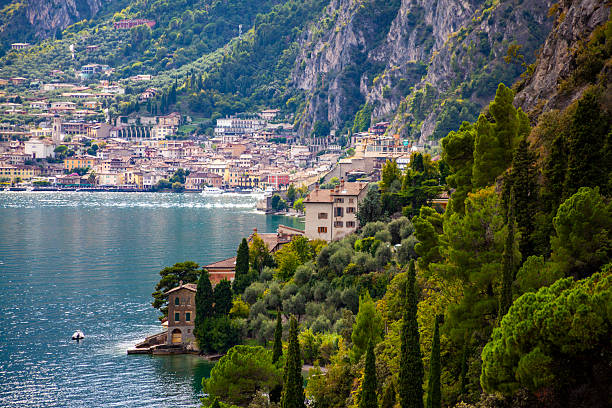 Landscape view of an Italian mansion with cypresses and olive trees along Lake Garda, Italy under a twilight sky.