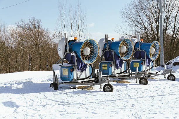 Snow cannon in winter mountains. Snow-gun spraying artificial ice crystals. Machine making snow