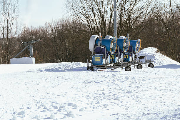 Snow cannon in winter mountains. Snow-gun spraying artificial ice crystals. Machine making snow