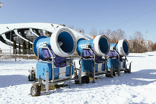 Snow cannon in winter mountains. Snow-gun spraying artificial ice crystals. Machine making snow