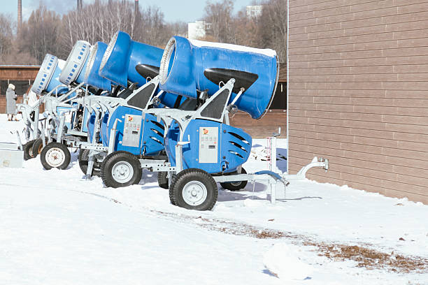 Snow cannon in winter mountains. Snow-gun spraying artificial ice crystals. Machine making snow