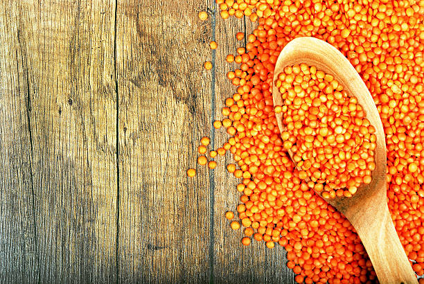 Red lentils on a wooden table. Copy space
