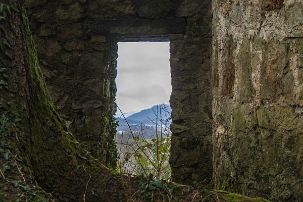 ancient stone window opening from an old castle, showing weathered masonry, historic architecture, and textured stone details with a medieval atmosphere