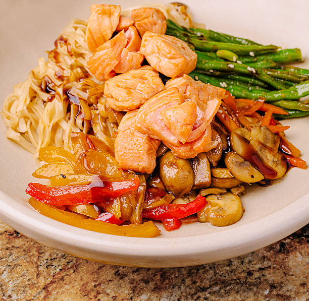 Delicious salmon dish with vegetables and noodles served in a bowl