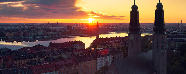 Central Stockholm at sunrise in summer. In the foreground is Södermalm and the towers of Högalidskyrkan. In the background is Kungsholmen, Stockholm city hall and lake Mälaren.