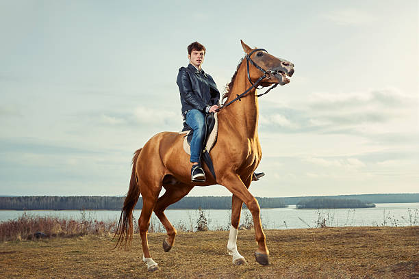 Photo of female friends enjoying horseback riding by the water