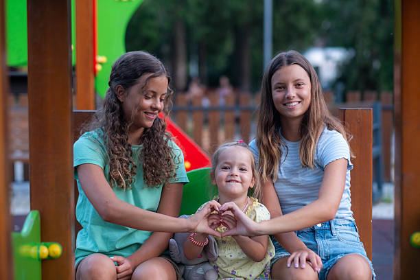 Young girls showing love and happiness at a park playground during summer