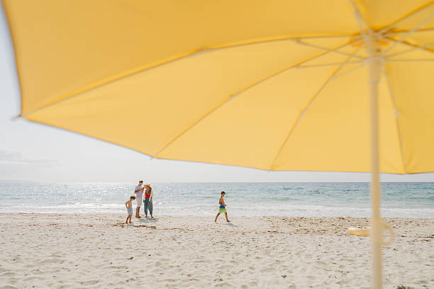 Photo of a family with two young boys, spending quality time together while on their beach vacation
