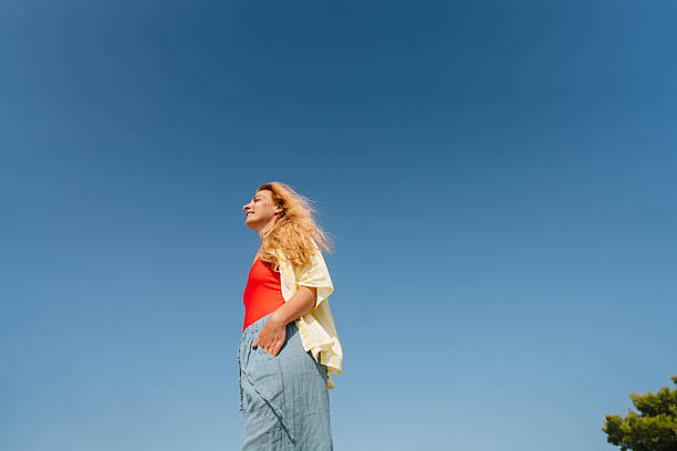 Photo of a mid adult woman enjoys sunshine and beautiful view on the local beach